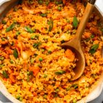 kimchi fried rice in grey speckled pot with wooden spoon on marble background