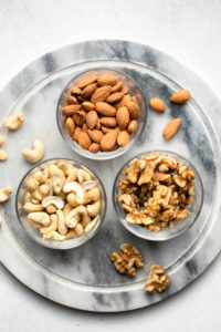 glass bowls of almonds, walnuts, and cashews