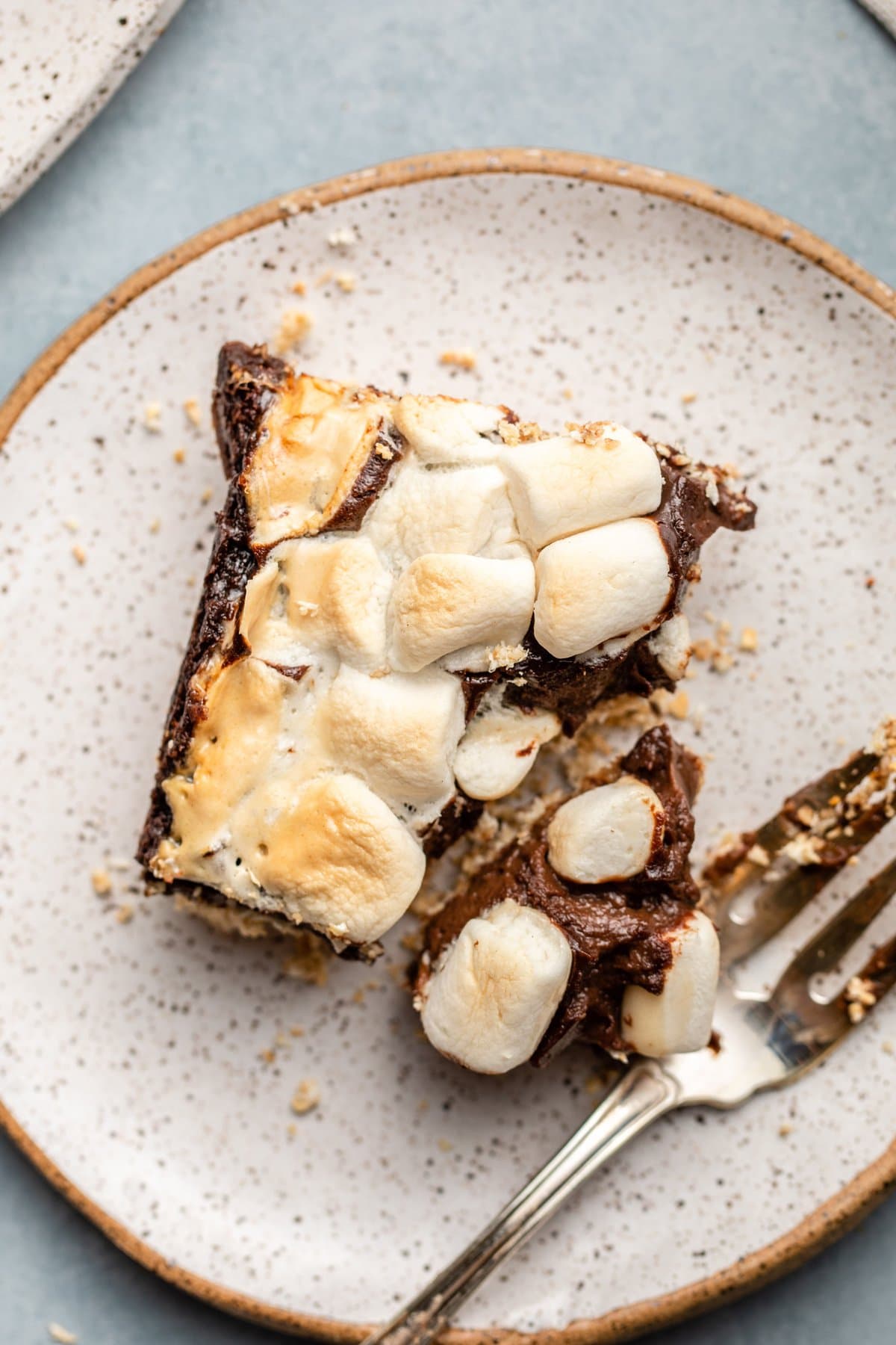 vegan smores bar on small white plate with bite taken out of it