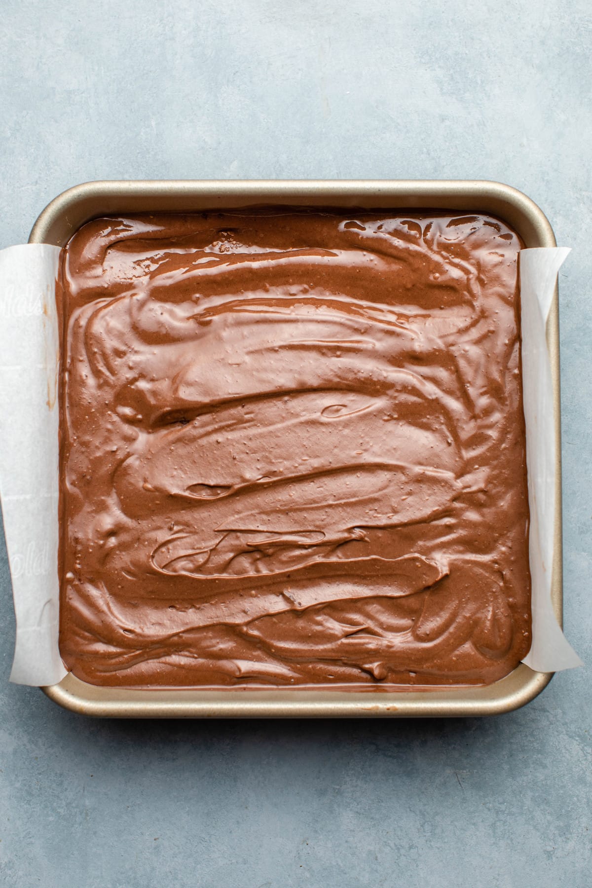 chocolate filling spread across graham cracker base in baking tin