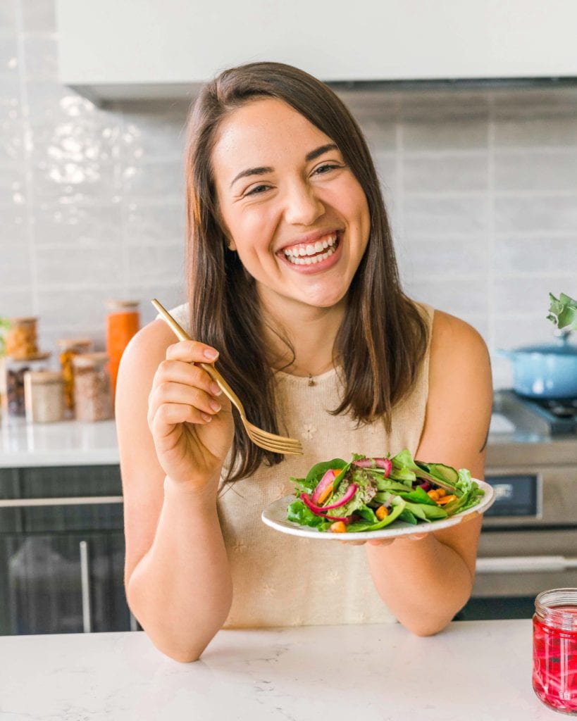 photo of caitlin smiling with plate of salad