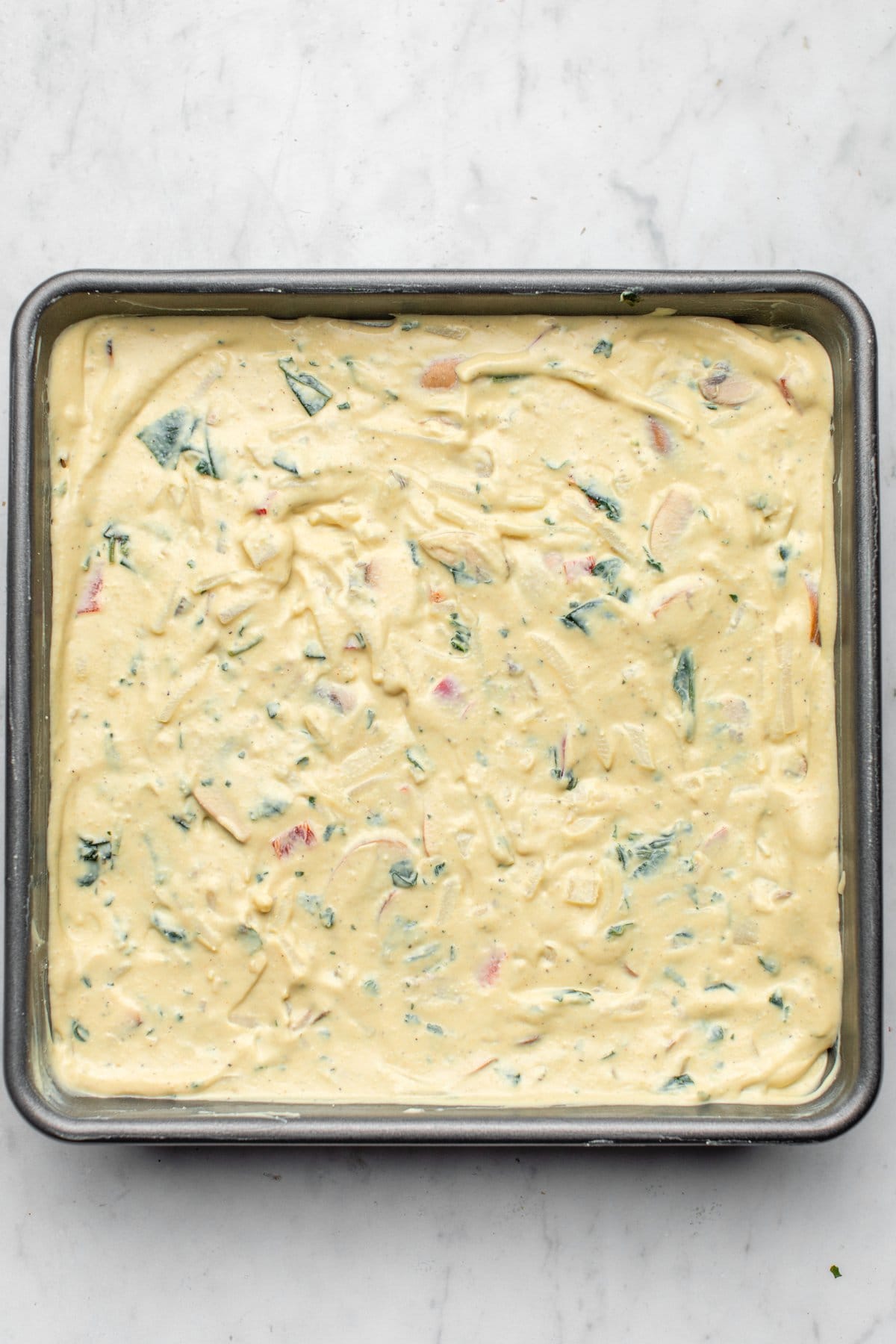unbaked vegan egg casserole in baking tray on marble background