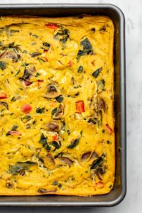 close up photo of vegan breakfast casserole in gray baking tin on marble background