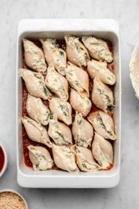 stuffed shells in white baking tray with marble background