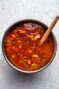 instant pot base filled with cooked minestrone soup on marble background