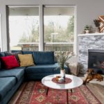 photo of furnished living room with sofa and puppy by fireplace