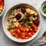 two bowls of beans, quinoa, and vegetables on marble background