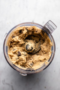 chickpea cookie dough batter in food processor with chocolate pulsed in