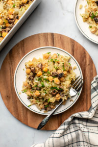 chickpea rice casserole on white plate with fork on marble background