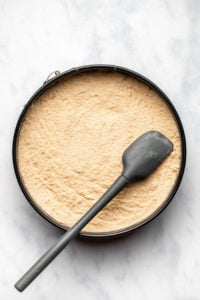 cheesecake filling spread into springform pan on marble background