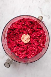 blended beet patty mixture in food processor on marble background