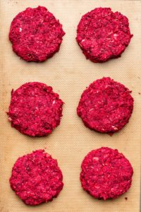 uncooked beet burger patties on silicone mat