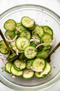 cucumber dill salad in glass bowl after mixing