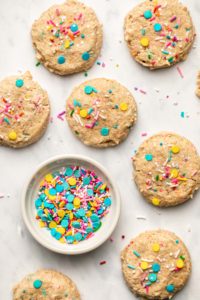 funfetti cookies on marble background with bowl of sprinkles
