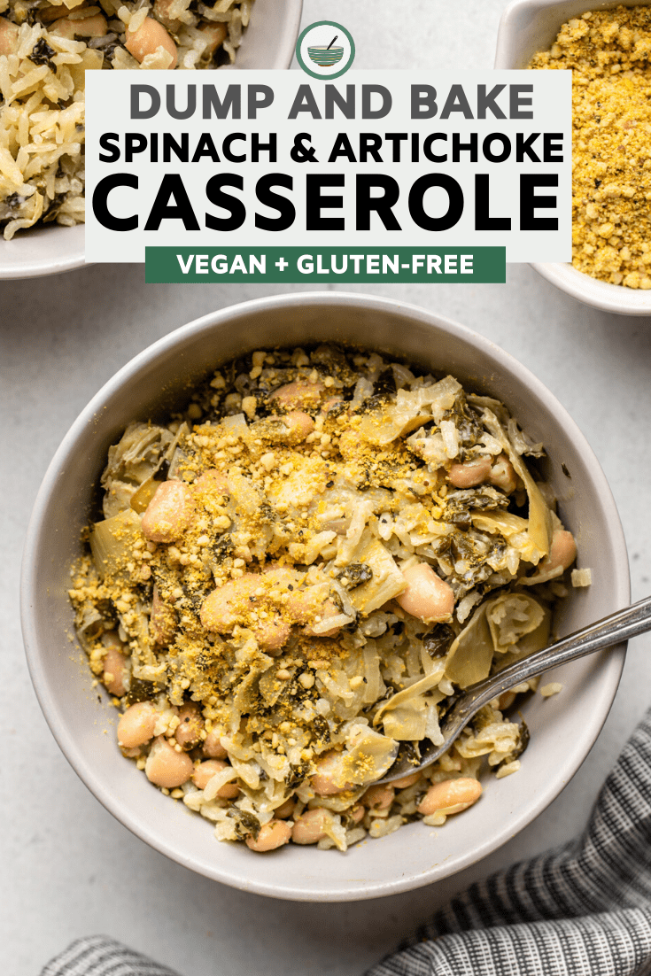 bowl of spinach & artichoke casserole topped with vegan parmesan on grey stone background