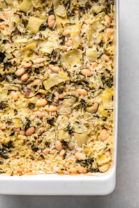 close up photo of spinach & artichoke casserole after baking in white casserole dish