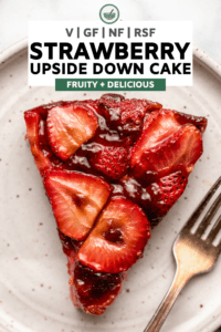 close up photo of slice of strawberry upside down cake on white plate with fork