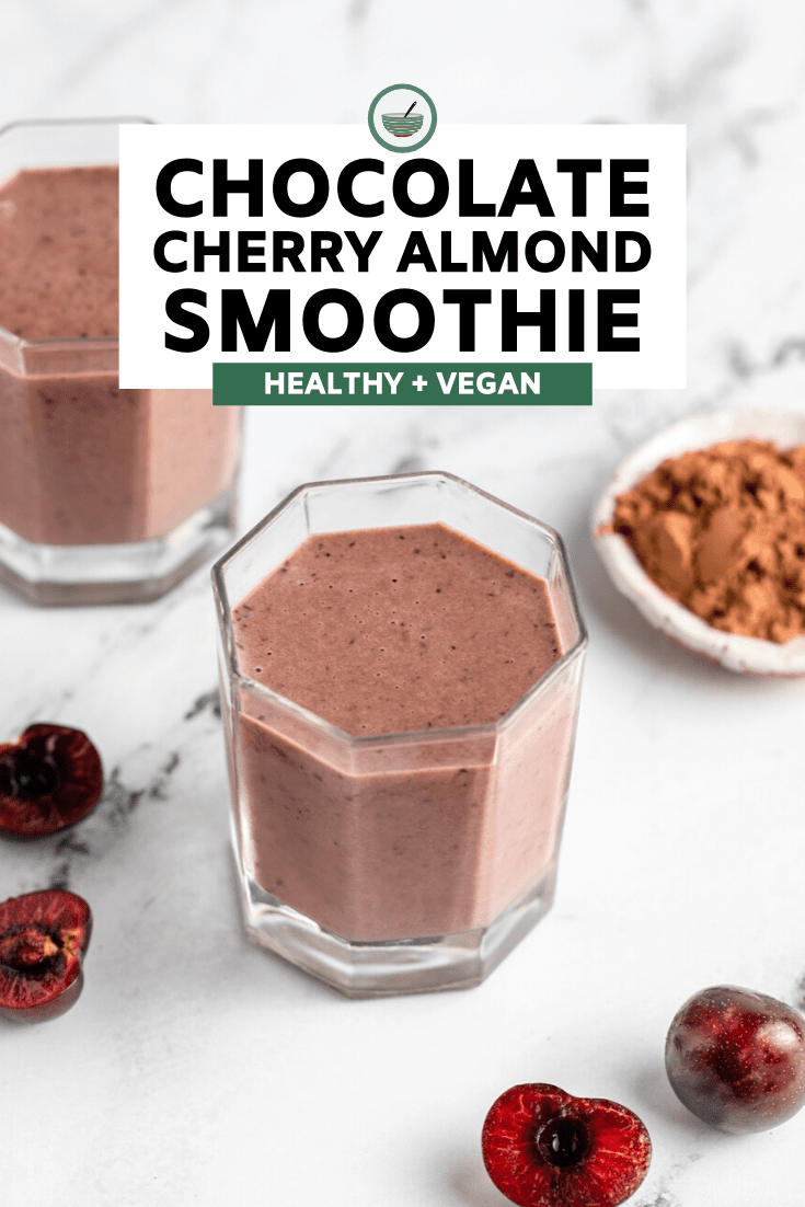 glass of chocolate cherry almond smoothie on marble background with fresh cherries