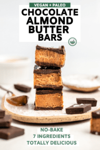 stack of 3 almond butter bars with bite taken out of top bar on white background