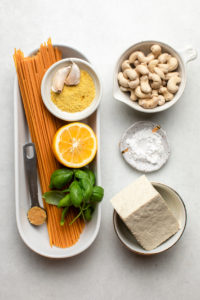 ingredients for lemon ricotta pasta in small white bowls on stone background