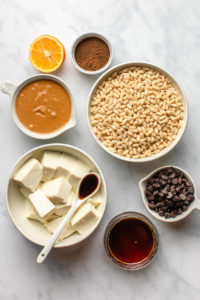 ingredients for no bake peanut butter cup pie in white bowls on marble background
