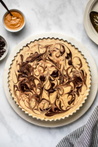 Completed peanut butter cup pie on marble serving tray on marble background
