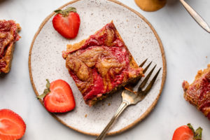 PB&J blondie on white plate with fresh strawberries and fork