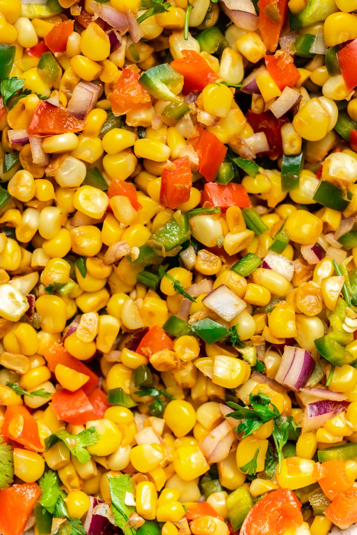 close up photo of mixed corn salsa to show seared corn kernels, bell pepper, onion, and cilantro