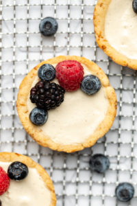 close up photo of vanilla custard tart topped with fresh berries