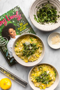 two bowls of sweet pea and corn risotto next to haile thomas' new cookbook