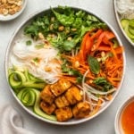 vegan vermicelli noodle bowl with tofu, carrot, and cucumber on white marble background