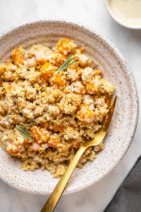 one pot quinoa with butternut squash in white bowl drizzled with tahini