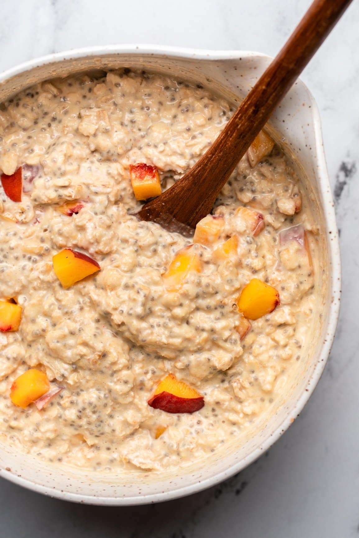 large bowl of peaches & cream oatmeal topped with pieces of chopped peach