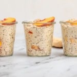 3 jars of peaches and cream overnight oatmeal topped with fresh peaches on marble table