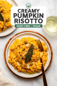 pumpkin risotto on white plate topped with oil, pumpkin seeds, and fried sage