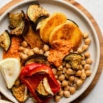 plate of roasted eggplant and red bell pepper with pan fried polenta, romesco sauce, and chickpeas