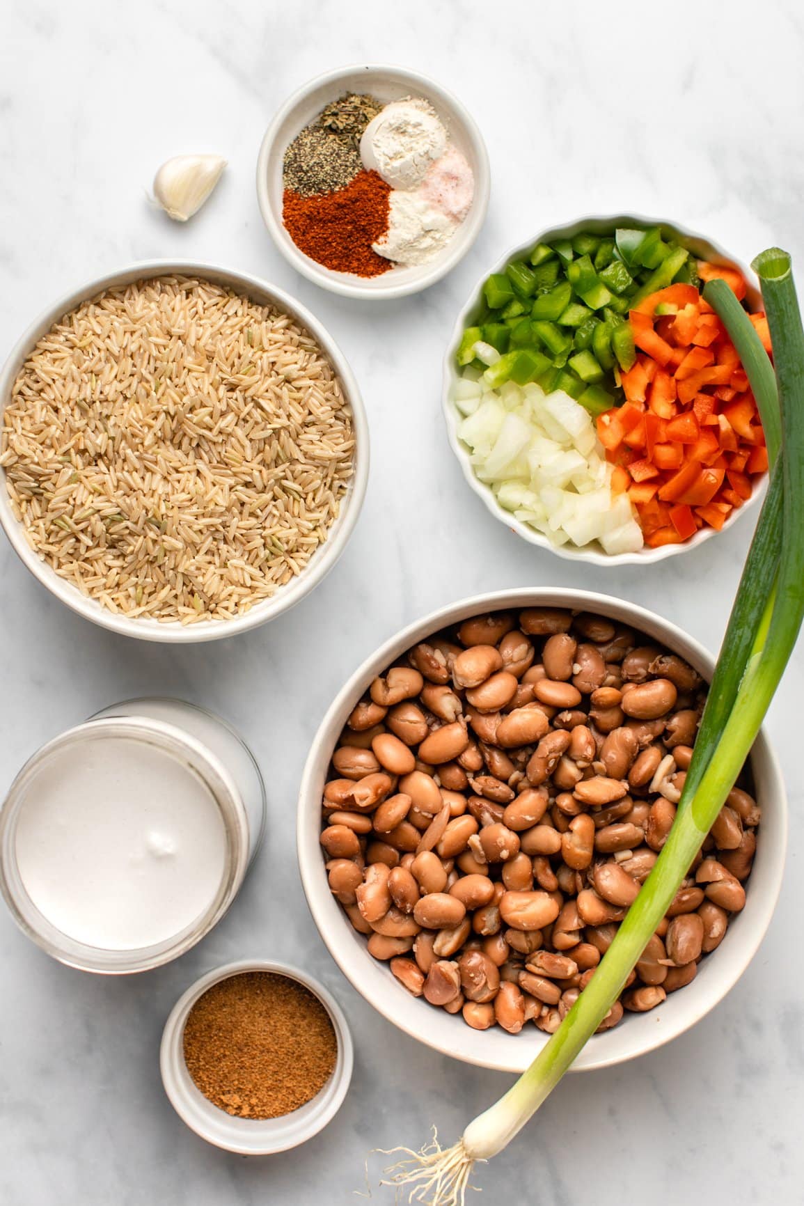 ingredients for rice and peas in small white bowls on light background
