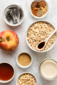ingredients for baked apple chai oatmeal in small white bowls