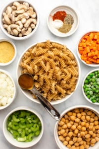 ingredients for no boil chickpea noodle casserole in white bowls on marble background
