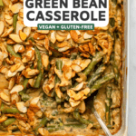 cooked green bean casserole in white dish with serving spoon