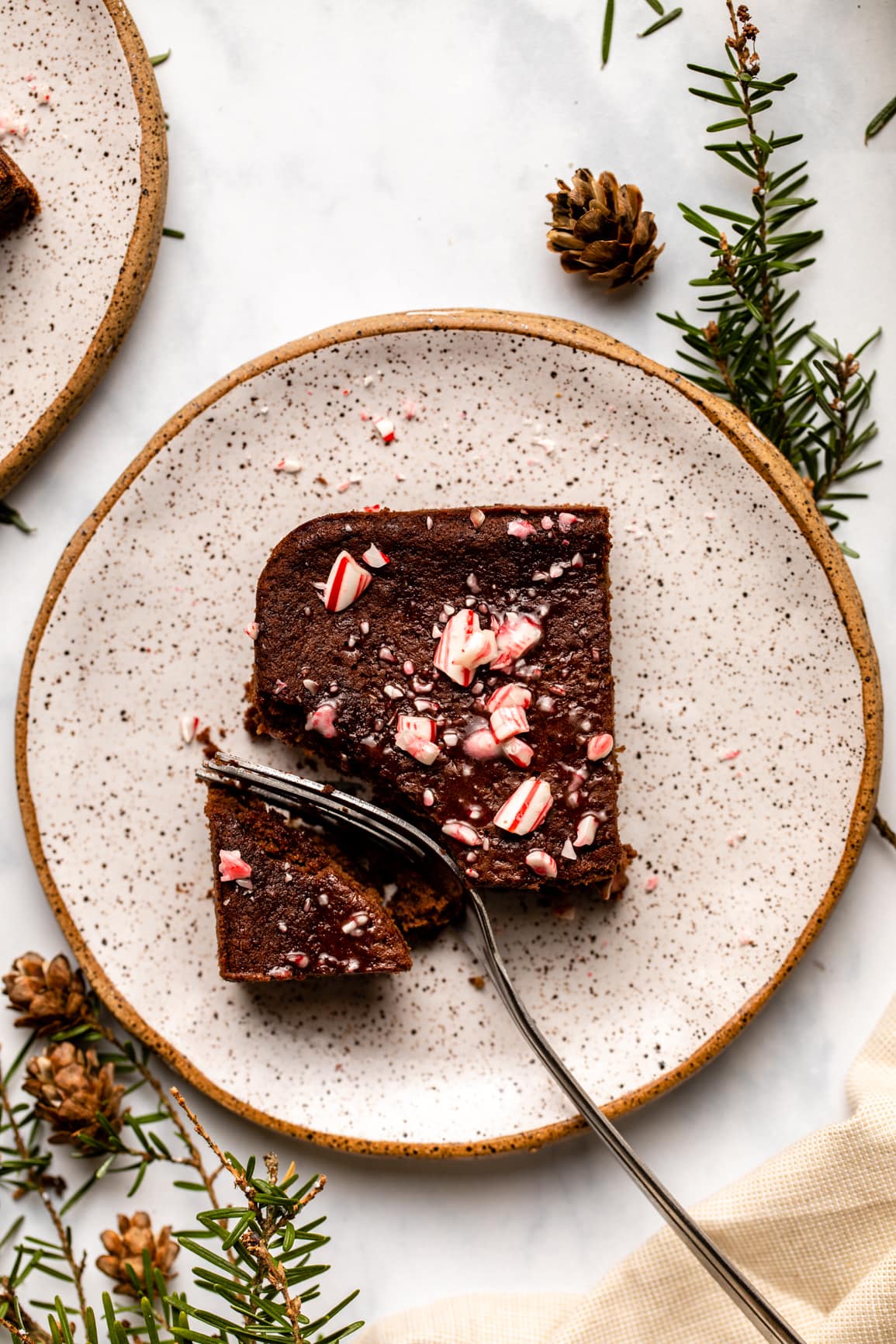 candy cane brownie on small white plate with fork cutting into it