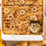 sliced banana bread oatmeal in white baking tray with yellow table linen
