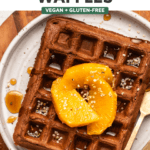 close-up photo of one chocolate orange waffle on white plate topped with hemp hearts orange slices and maple syrup