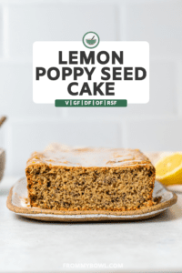 front-on shot of fluffy lemon poppy seed cake topped with lemon glaze against bright kitchen tile
