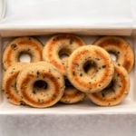 Baked chocolate chip vegan donuts arranged in white recipe tin on marble background