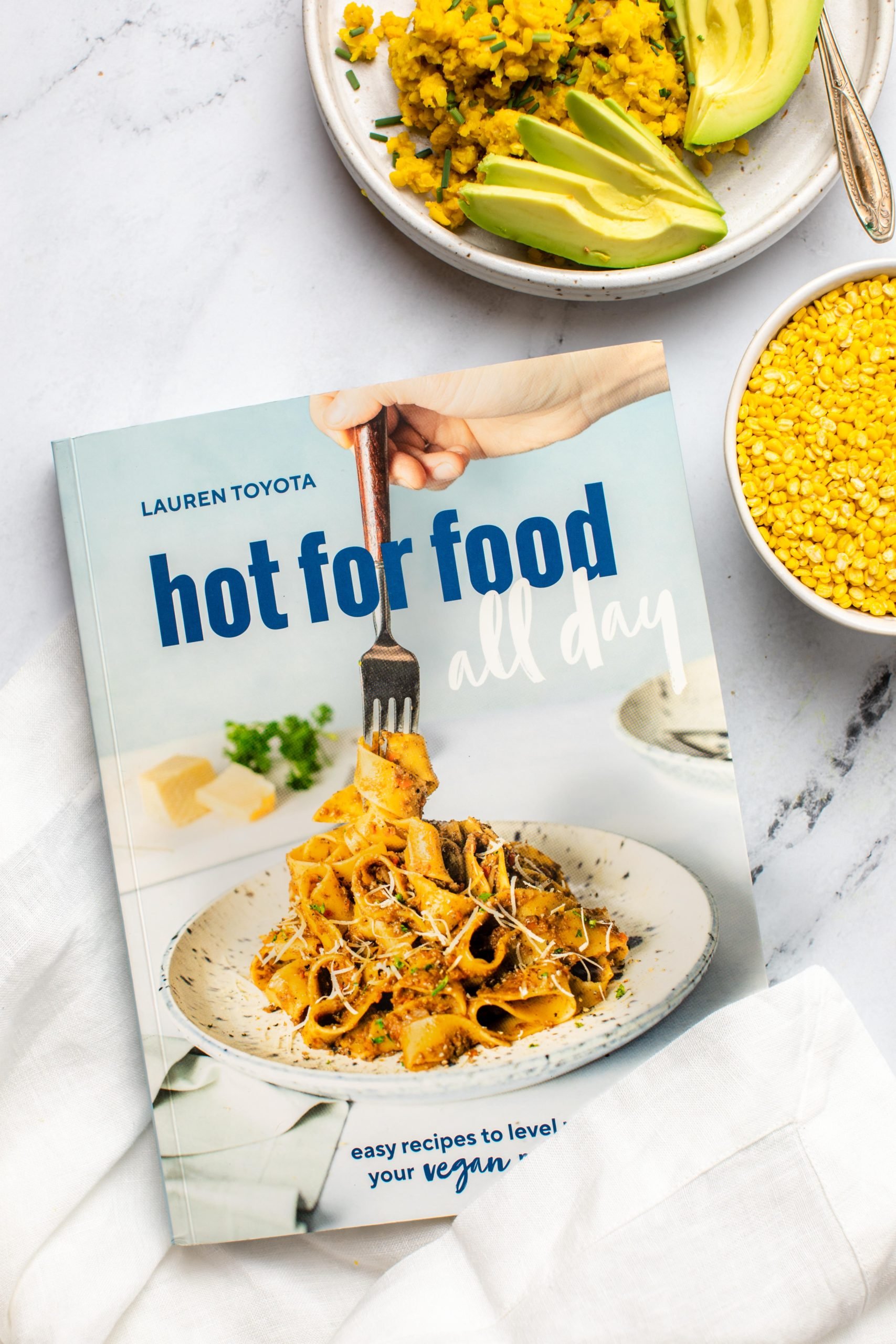 hot for food cookbook on marble background with bowl of split mung beans and cooked mung bean scramble of to the right side