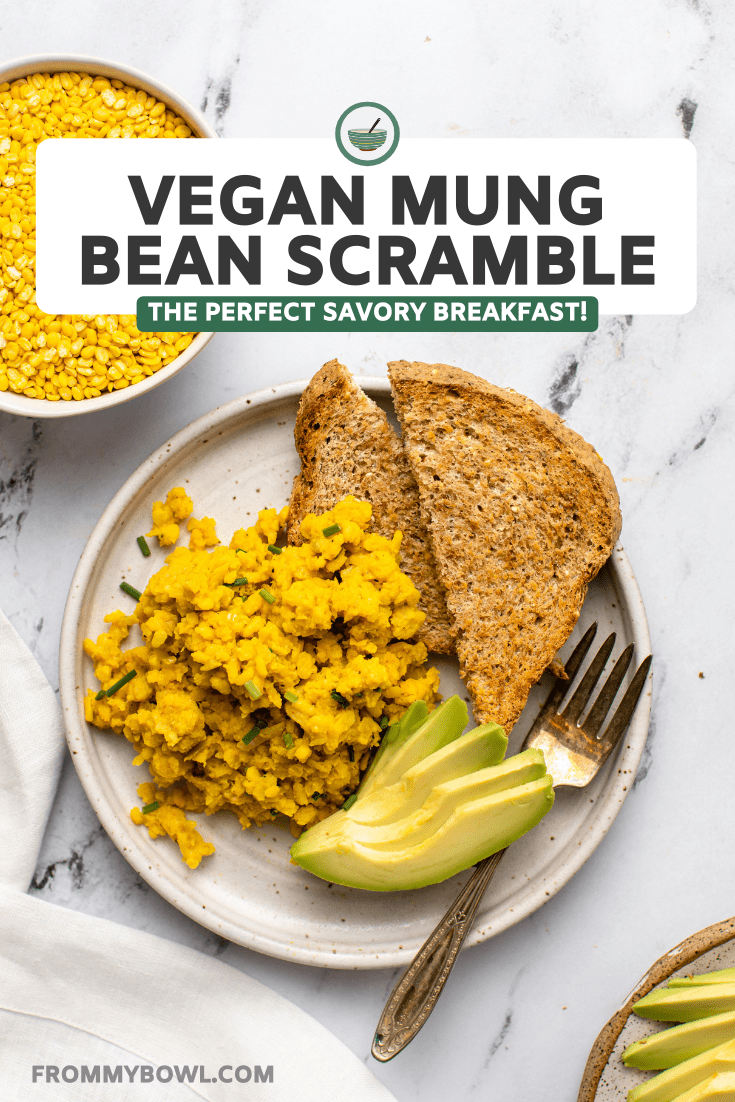 white plate of mung bean scramble, toast, and avocado on marble background
