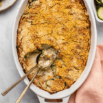 Baked zucchini gratin in white casserole dish with crispy cornmeal topping