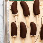Chocolate covered banana pops on a baking sheet