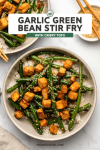 Garlic Green Bean Stir Fry with Crispy Tofu over white rice in large bowl on marble background